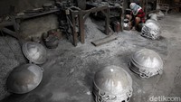 Seorang pekerja sedang membuat wajan berbahan alumunium di industri rumahan pembuat wajan bu Wagiyo, Mutihan, Banguntapan, Bantul, Yogyakarta, Selasa (19/1/2021).