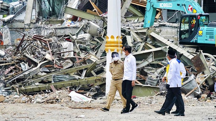 Jokowi Tinjau Lokasi Gempa Mamuju In this photo released by the Indonesian Presidential Palace, President Joko Widodo, second right, talks to an official as as he inspects an earthquake-damaged government building in Mamuju, West Sulawesi, Indonesia, Tuesday, Jan. 19, 2021. Widodo visited the areas where a deadly earthquake left thousands of people homeless in an effort to reassure them the government's response is reaching those struggling after the quake. (Indonesian Presidential Palace via AP)