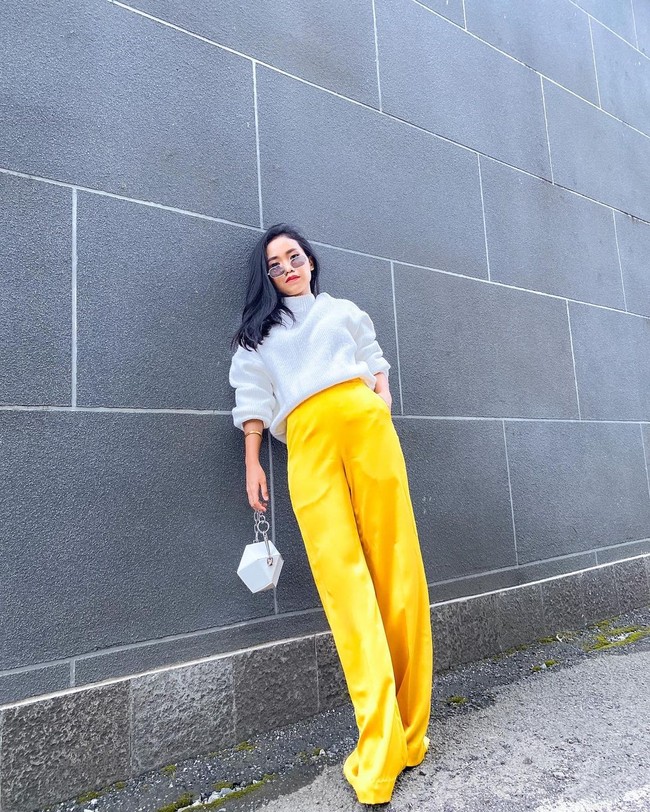 Wanita 27 tahun ini juga kerap tampil ala Korean looks. Dalam foto ini, Ayya Renita mengenakan celana kulot kuning rancangan desainer Revigo Guntara dan atasan putih yang tangannya ia serut hingga ke siku. Kece ya! Foto: Instagram @ayyrenita93.