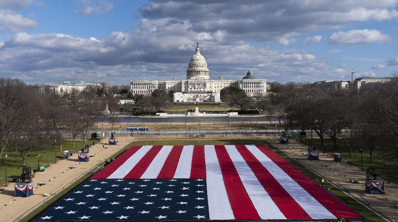 Ribuan Bendera AS Meriahkan Pelantikan Joe Biden The U.S. Capitol is seen between flags placed on the National Mall ahead of the inauguration of President-elect Joe Biden and Vice President-elect Kamala Harris, Monday, Jan. 18, 2021, in Washington.