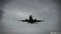 Pesawat saat mengudara di gumpalan awan kelam yang menggantung di langit Jakarta, Selasa (19/01/2021).