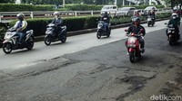 Pengendara sepeda motor memilih melintas di jalur transjakarta untuk menghindari jalan berlubang.