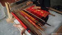 Semakin rumit motif tenun maka semakin banyak bilah kayu pemisah benang dan semakin berat alatnya, kata Rina.