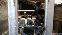 Seorang pekerja melakukan proses pengecatan.