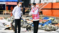 Presiden Joko Widodo (kiri) berbincang dengan Menteri Perhubungan Budi Karya Sumadi (kanan) saat melihat sejumlah temuan serpihan pesawat Sriwijaya Air PK-CLC nomor penerbangan SJ 182 rute Jakarta-Pontianak di Posko Darurat Evakuasi di Dermaga JICT II, Pelabuhan Tanjung Priok, Jakarta, Rabu (20/1/2021).   
