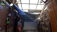Warga melihat kondisi atap rumah kos yang rusak akibat diterpa angin puting beliung di Desa Pecatu, Badung, Bali, Kamis (21/1/2021).