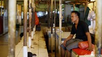 Seorang pedagang terlihat hanya duduk-duduk di lapaknya.