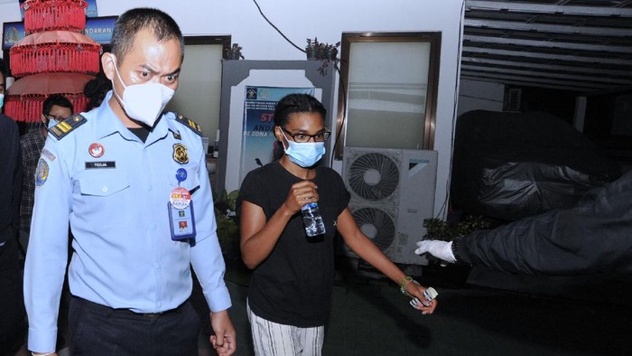 Petugas Imigrasi mengawal warga negara Amerika Serikat Saundra Michelle Alexander (kanan) yang merupakan rekan dari Kristen Antoinette Gray saat akan menuju ke Bandara Internasional I Gusti Ngurah Rai di Kantor Imigrasi Kelas I TPI Denpasar, Bali, Rabu (20/1/2021). Kristen Gray yang cuitannya viral di akun Twitter @kristentootie berupa ajakan bagi orang asing untuk pindah ke Bali pada masa pandemi COVID-19 dan diduga telah menyebarkan informasi lain yang dianggap dapat meresahkan masyarakat dideportasi bersama Saundra Michelle ke Amerika Serikat karena diduga melanggar pasal 75 ayat 1 Undang-undang Nomor 6 Tahun 2011 tentang Keimigrasian. ANTARA FOTO/Fikri Yusuf/wsj.