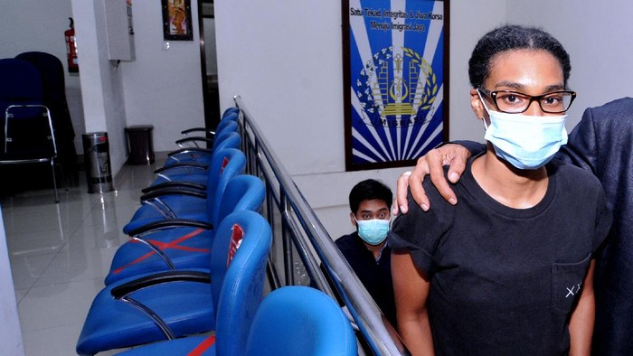 Petugas Imigrasi mengawal warga negara Amerika Serikat Saundra Michelle Alexander (kanan) yang merupakan rekan dari Kristen Antoinette Gray saat akan menuju ke Bandara Internasional I Gusti Ngurah Rai di Kantor Imigrasi Kelas I TPI Denpasar, Bali, Rabu (20/1/2021). Kristen Gray yang cuitannya viral di akun Twitter @kristentootie berupa ajakan bagi orang asing untuk pindah ke Bali pada masa pandemi COVID-19 dan diduga telah menyebarkan informasi lain yang dianggap dapat meresahkan masyarakat dideportasi bersama Saundra Michelle ke Amerika Serikat karena diduga melanggar pasal 75 ayat 1 Undang-undang Nomor 6 Tahun 2011 tentang Keimigrasian. ANTARA FOTO/Fikri Yusuf/wsj.