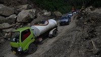 Sejumlah kendaraan mulai bisa melintas di Jalan Trans Sulawesi Poros Majene-Mamuju yang terkena longsor di Majene, Sulawesi Barat, sejak Rabu (20/1/2021) sore kemarin.