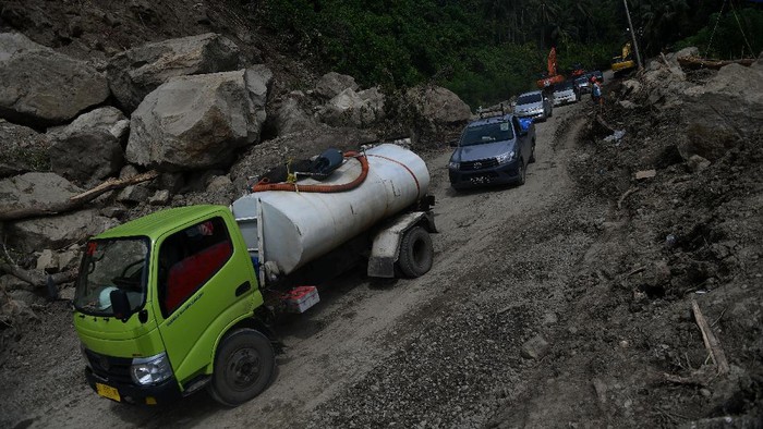 JALUR POROS MAJENE-MAMUJU Sejumlah kendaraan melintas di Jalan Trans Sulawesi Poros Majene-Mamuju yang terkena longsor di Majene, Sulawesi Barat, Rabu (20/1/2021). Jalur yang sempat terputus akibat longsor tersebut sudah bisa dilalui dengan sistem buka tutup arus kendaraan dari dua arah. ANTARA FOTO/Sigid Kurniawan/hp.