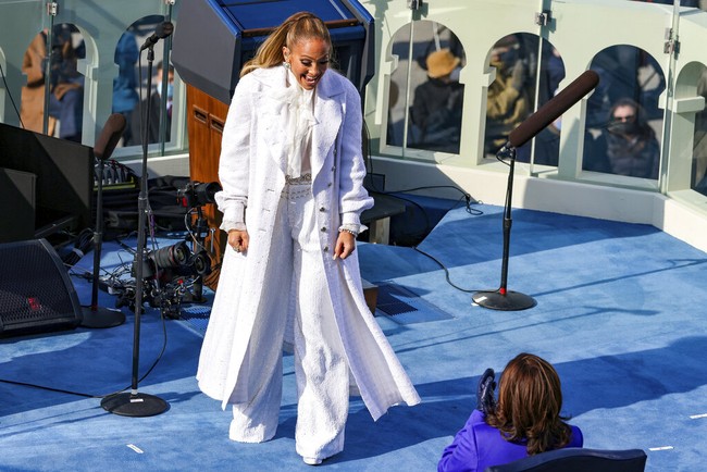 Selain Lady Gaga, penyanyi dan aktris Jennifer Lopez turut menyumbangkan suara merdunya di inaugurasi Joe Biden. Bak malaikat, J.Lo memesona dengan blus bergaya vintage, serta celana pipa dan coat serba putih dari koleksi Fall 2020 Chanel. (Foto: AP/Tasos Katopodis)