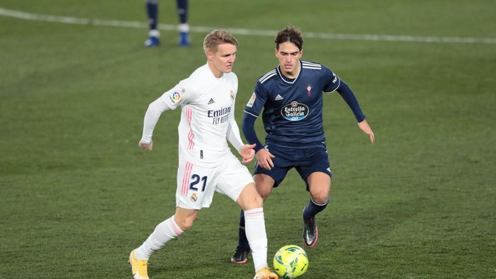 MADRID, SPAIN - JANUARY 02: Martin Oedegaard of Real Madrid battles for possession with Denis Suarez of Celta Vigo during the La Liga Santander match between Real Madrid and RC Celta at Estadio Santiago Bernabeu on January 02, 2021 in Madrid, Spain. Sporting stadiums around Spain remain under strict restrictions due to the Coronavirus Pandemic as Government social distancing laws prohibit fans inside venues resulting in games being played behind closed doors. (Photo by Gonzalo Arroyo Moreno/Getty Images)