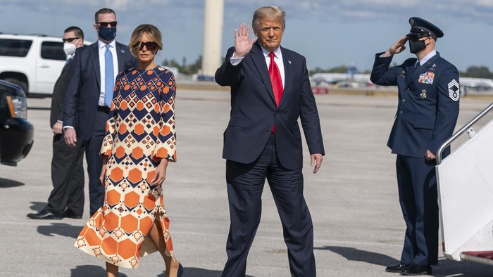 Former President Donald Trump and Melania Trump wave as they disembark from their final flight on Air Force One at Palm Beach International Airport in West Palm Beach, Fla., Wednesday, Jan. 20, 2021. (AP Photo/Manuel Balce Ceneta)