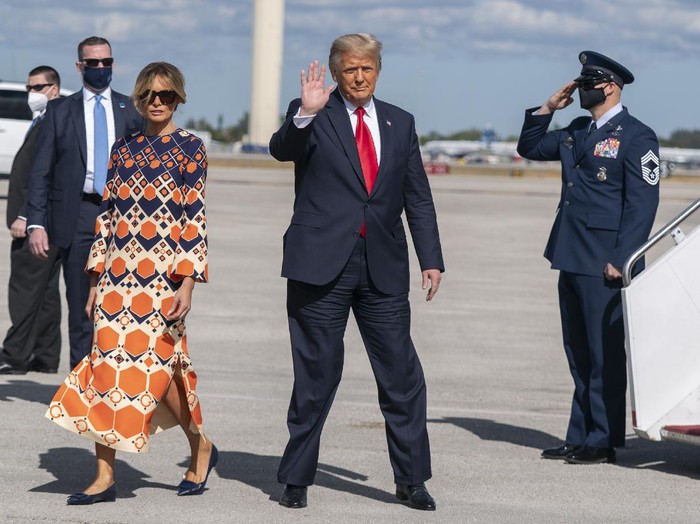 Former President Donald Trump and Melania Trump wave as they disembark from their final flight on Air Force One at Palm Beach International Airport in West Palm Beach, Fla., Wednesday, Jan. 20, 2021. (AP Photo/Manuel Balce Ceneta)