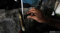 Pekerja mengukur kadar alkohol saat proses produksi etanol.