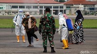 Petugas dari dinas Sosial provinsi Jawa Tengah menyemprotkan disinfektan kepada pengungsi gempa Sulawesi Barat beserta kru pesawat yang transit menggunakan pesawat Hercules di Bandara Adi Soemarmo, Solo, Jawa Tengah, Kamis (21/1).