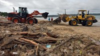 Sejumlah alat berat membersihkan sampah kiriman di Pantai Kedonganan, Badung, Bali, Kamis (21/1/2021).