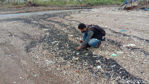 Warga mengambil batu bara yang berhamburan di Pantai Sekembu, Jepara, Selasa (21/1/2021)