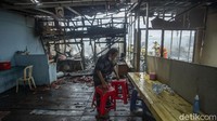 Seorang warga berusaha menyelamatkan barangnya dari kebakaran.