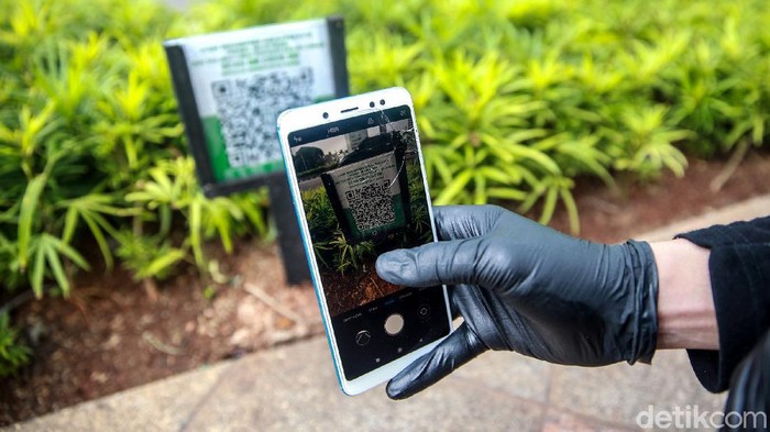 Baru Dipasang, Barcode Tanaman Penuh Uap Air dan Susah Discan Warga mencoba memindai (menscan) barcode tanaman di sejumlah tanaman yang ada di Jalan Thamrin, Jumat (22/1/2020).