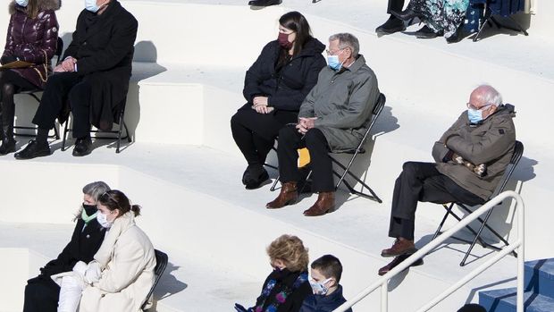 Gaya Senator Vermont, Bernie Sanders, yang memakai jaket musim dingin dan sarung tangan bermotif menjadi viral di media sosial. (AP/Carolyn Kaster)
