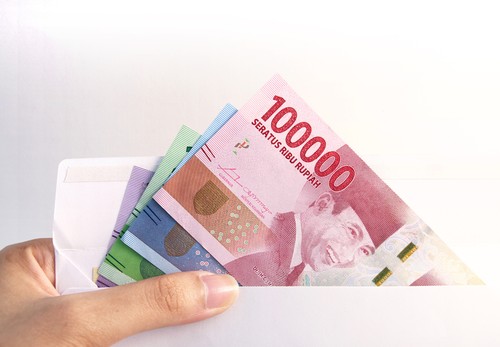 woman hand showing envelope and Indonesia rupiah money