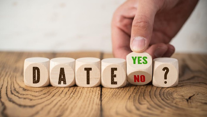Precious moments of love. Close up portrait of handsome bearded guy kissing his girlfriend in cheek while she hugging him. Lady closing eyes with pleasure and smiling