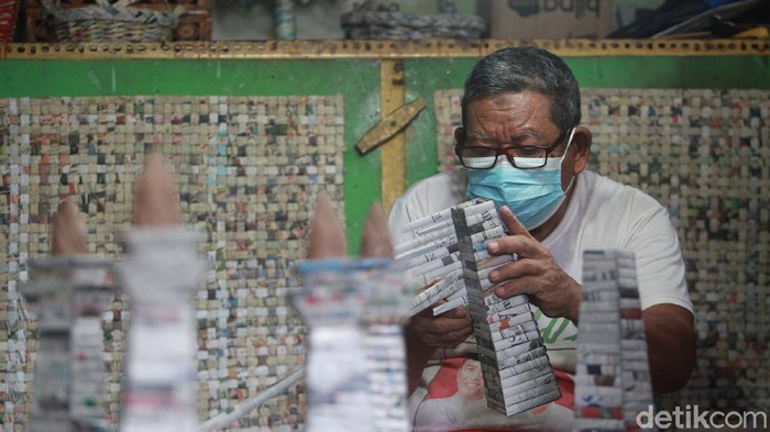 Tri Sugiarti (43) bersama kedua orang tuanya Sugito dan Surip mendaur ulang sampah menjadi kreasi art paper yang bernilai ekonomis di Bank Sampah Tri Alam Lestari, di Pesanggrahan, Jakarta Selatan, Jumat (22/1/2021).