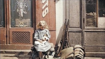 Seorang gadis kecil dengan perlengkapan senjata tentara di sampingnya, dijepret di Paris pada 1914. Foto: Imgur