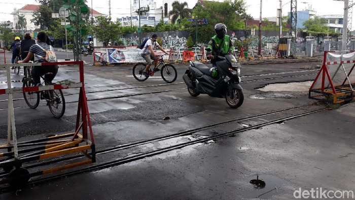 Lewat Perlintasan KA Ini, Motor Harus Dituntun Sebuah perlintasan rel kereta api di Kota Yogyakarta hanya boleh dilintasi warga, sepeda dan becak kayuh. Akibatnya sepeda motor yang nekat melintas harus dituntun.