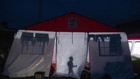 Seorang anak beraktifitas dibalik tenda darurat untuk pengungsi yang dibangun oleh Kementerian Sosial dan BNPB untuk korban gempa bumi di Lapangan Manakarra, Mamuju, Sulawesi Barat.  ANTARA FOTO/Sigid Kurniawan