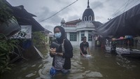 Warga melintasi banjir yang menggenangi kawasan padat penduduk di Kabupaten Banjar, Kalimantan Selatan, Jumat (15/1/2021). Berdasarkan data yang telah dihimpun Badan Penanggulangan Bencana Daerah (BPBD) Provinsi Kalimantan Selatan dari tanggal 1 hingga 14 Januri, sebanyak 19.452 rumah terendam banjir di sejumlah wilayah di Kalimantan Selatan.