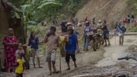 Warga membawa logistik bantuan korban bencana banjir bandang, di Desa Arangani, Kabupaten Hulu Sungai Tengah, Kalimantan Selatan, Jumat (22/1/2021).