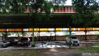 Sekeliling bangunan Stasiun KA tampak dikelilingi pagar seng. Saat masuk ke dalam stasiun terlihat ada sejumlah kendaraan roda empat yang berjajar di sana.