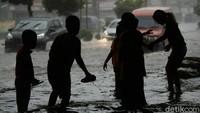 Salah satu anak yang bermain di tengah banjir itu mengaku tak takut bermain di tengah jalan yang tergenang banjir.