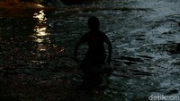 Meski berbahaya, anak-anak ini tetap bermain di genangan banjir tersebut.