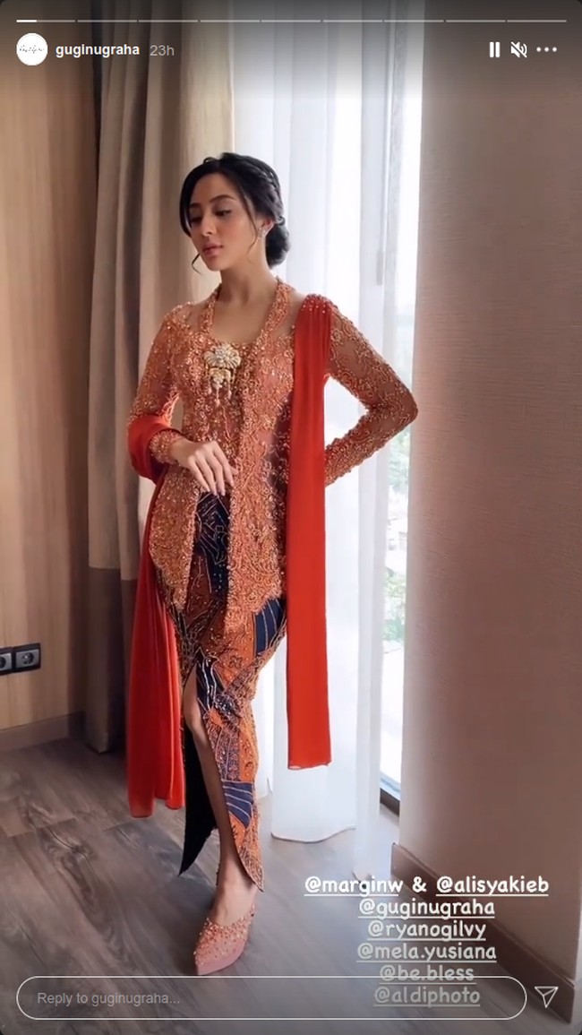Sedangkan bawahannnya, dipilih batik dengan campuran warna oranye dan biru tua yang menyatu dengan keseluruhan gaya. Sedangkan untuk sepatu, calon mempelai itu memakai high heels dengan detail embellishment yang juga bernuansa peach. Foto: Instagram @guginugraha