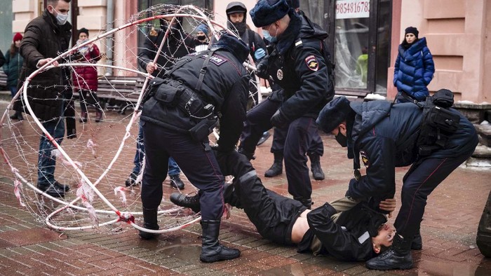 Police officers detain a man dressed in a horned, fur hat, and holding Russian flag during a protest against the jailing of opposition leader Alexei Navalny in Moscow, Russia, Saturday, Jan. 23, 2021. Russian police on Saturday arrested hundreds of protesters who took to the streets in temperatures as low as minus-50 C (minus-58 F) to demand the release of Alexei Navalny, the country's top opposition figure. (AP Photo/Pavel Golovkin)