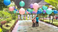 Liat tuh guys, keluarga itu sedang mengabadikan momen dibawah balon-balon yang indah
