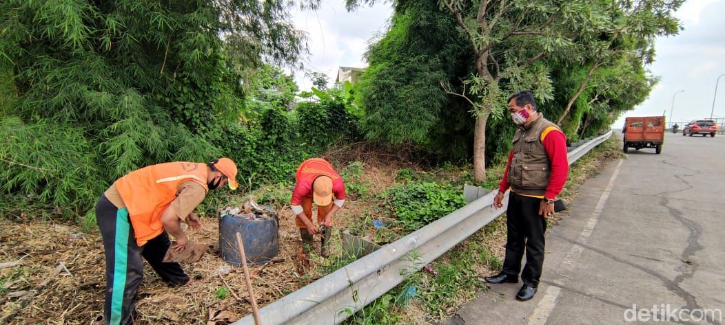 Bersih-bersih di pinggir jalan akses menuju Gerbang Tol Kalimalang 1, Bekasi, 25 Januari 2021. (Taufieq Renaldi Arfiansyah/detikcom)