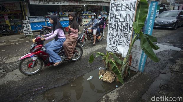 Jalan Pabuaran, Bojong Gede, Kabupaten Bogor, Jawa Barat, rusak parah. Warga menyindirnya dengan memasang spanduk hingga menanam pohon pisang.