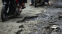 Pengendara melintas di Jalan Pabuaran, Bojong Gede, Jawa Barat, yang rusak dan berlubang.