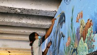 Para pemuda karang taruna dan mahasiswa IKJ mengerjakan mural sejak Minggu lalu.