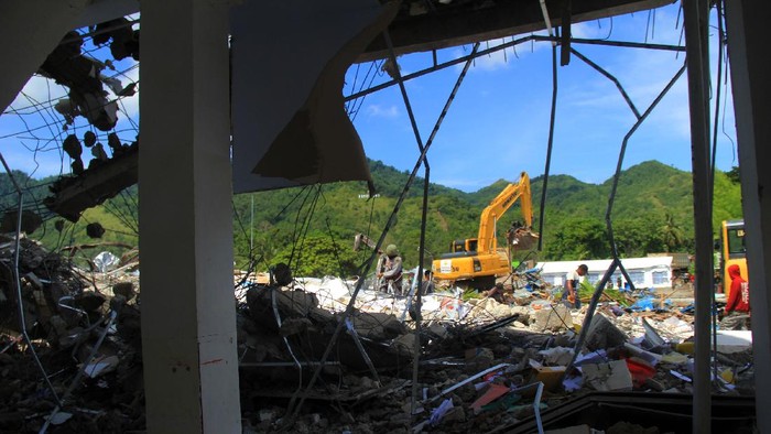 Sejumlah pekerja mencari sisa puing bangunan sekolah SMK 1 Rangas yang roboh pasca gempa bumi di Mamuju, Sulawesi Barat, Selasa (26/1/2021). Dinas Pendidikan dan Kebudayaan Sulbar menyatakan sebanyak 117 sekolah rusak akibat dampak gempa bumi Magnitudo 6,2 yang terjadi pada Jumat (15/1) lalu. ANTARA FOTO / Akbar Tado