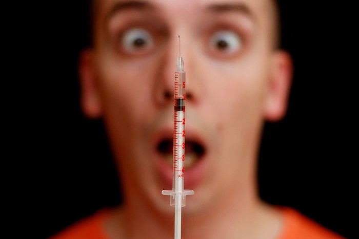 takut jarum suntik Frightened face of a man and a syringe - fear of injection.