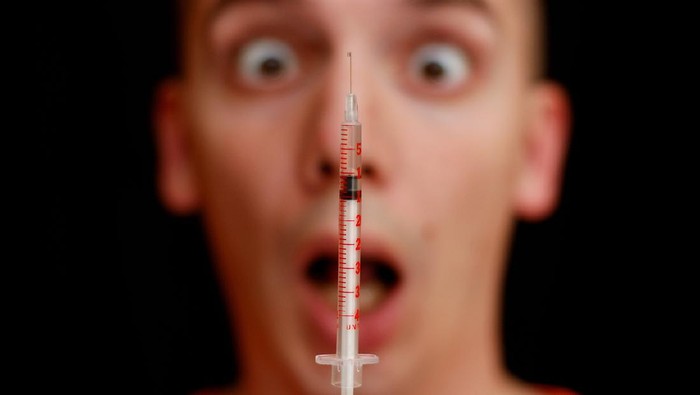 takut jarum suntik Frightened face of a man and a syringe - fear of injection.