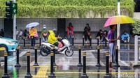 Sejumlah warga beraktivitas saat hujan mengguyur kawasan Jakarta, Rabu (27/1/2021).