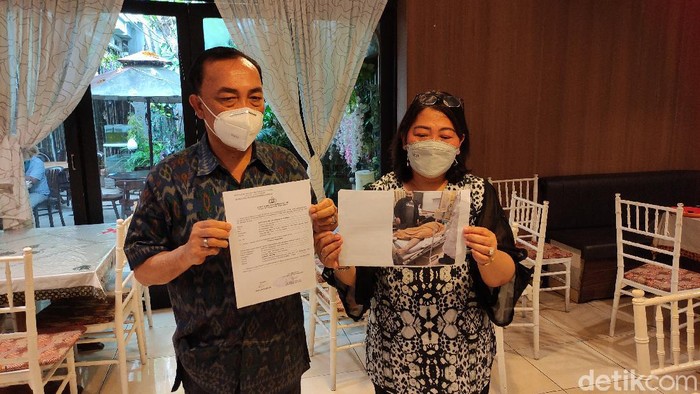 Erni Marsaulina (50) dan Raplan Sianturi (59) menunjukkan surat aduan ke Polda Jateng dan foto putra mereka yang meninggal di ruang isolasi, Rabu (27/1/2021).