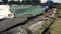 Sejumlah kendaraan melintas di dekat jalan tol yang ambles di ruas tol Surabaya-Gempol KM 06+200, di Surabaya, Jawa Timur, Rabu (27/1/2021). Terjadinya kemacetan panjang ini membuat polisi menghimbau agar para pengendara dari arah Perak Surabaya menghindari jalur dengan cara turun di Gerbang Tol Margomulyo kemudian masuk ke arteri dan naik di Gerbang Tol Gunungsari.